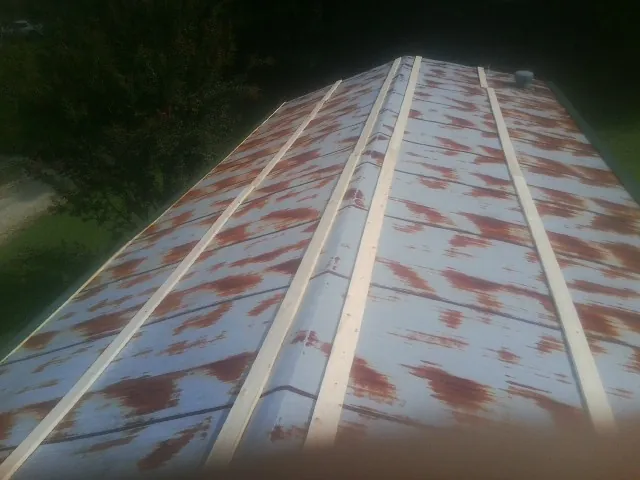 Rusted metal roof panels with new wood purlins before replacement — Storm Damage Roof Repair in Hertford by Roofing Brothers