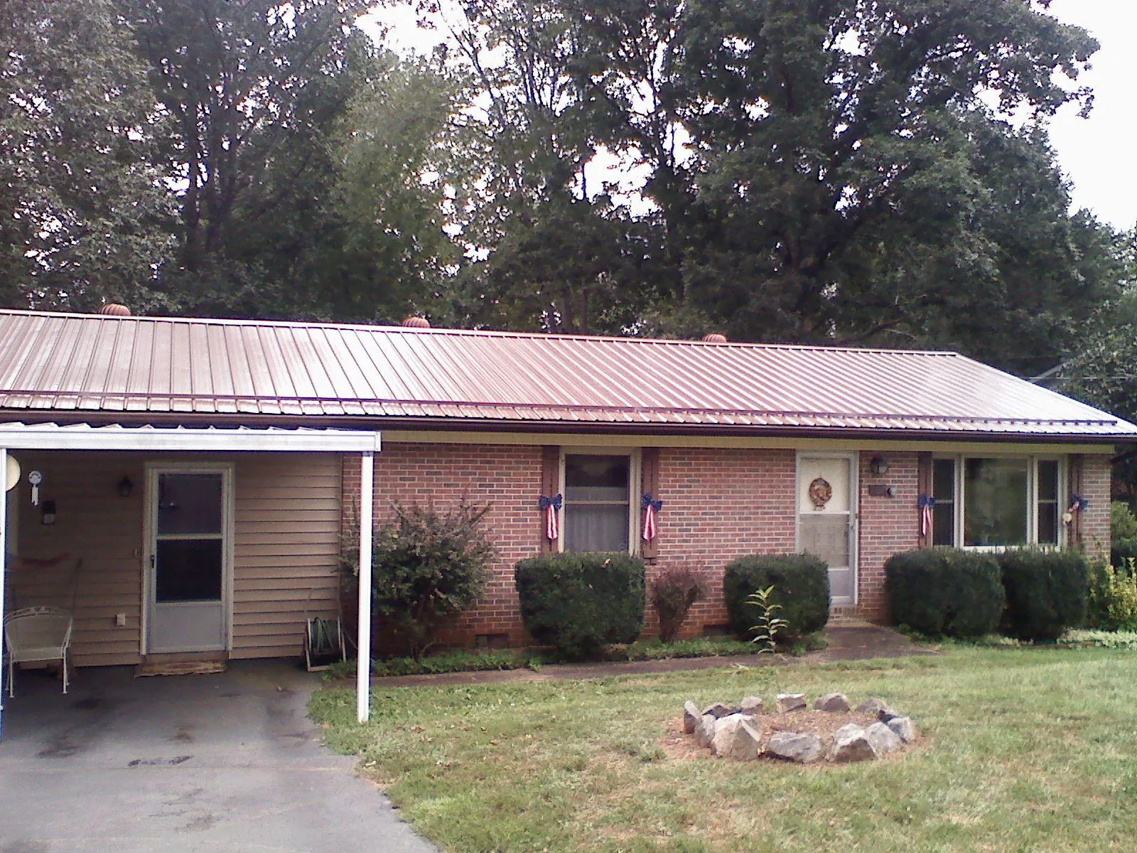 Bronze metal roof and carport on a brick ranch home — Roof Repair work by our crew in Hertford